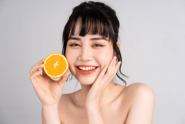 Nuori aasialainen nainen ihonhoito oranssi - Valokuva, kuva