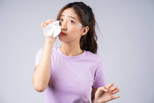 Young Asian woman wipes her tears with a tissue - Foto, immagini