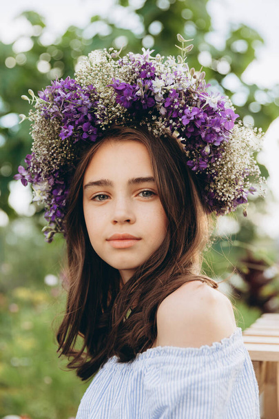 Милая 13-летняя девочка несет корзину красивых цветов на цветочном поле со счастьем - Фото, изображение