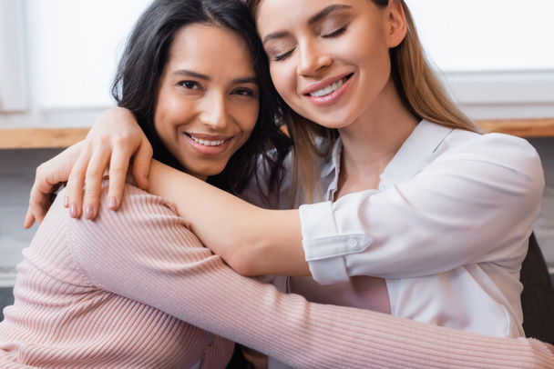 happy lesbian couple embracing each other in living room - Photo, image