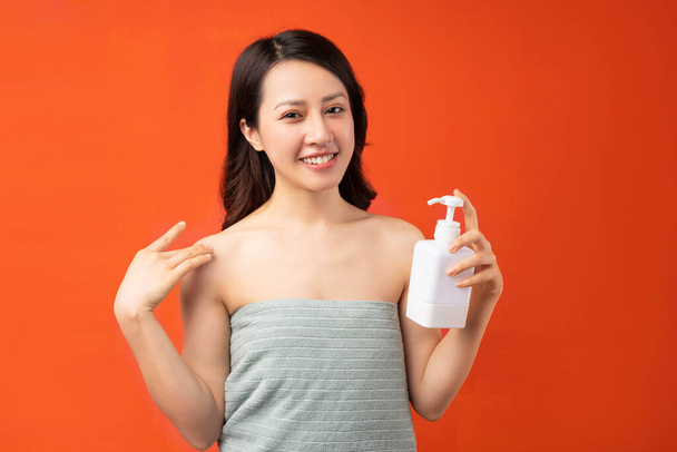Beautiful young Asian girl taking skin care with a cheerful expression - Valokuva, kuva
