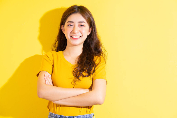 Menina asiática posando no fundo amarelo - Foto, Imagem