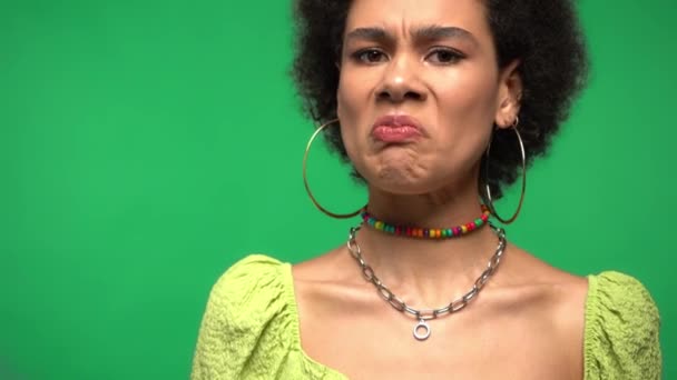 Irritierte Afroamerikanerin blickt isoliert auf grüne Kamera  - Filmmaterial, Video