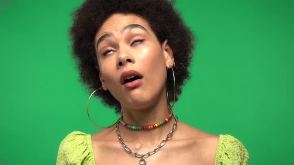 Skeptische Afroamerikanerin blickt isoliert auf grüne Kamera  - Filmmaterial, Video