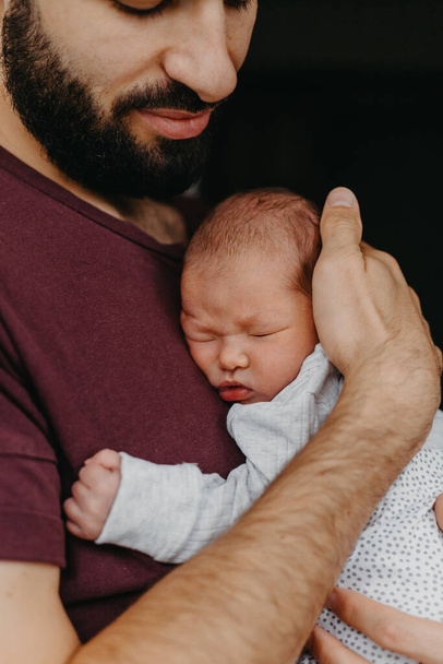 home photos of a newborn baby in the arms of father. Selective focus, noise effect - Foto, imagen