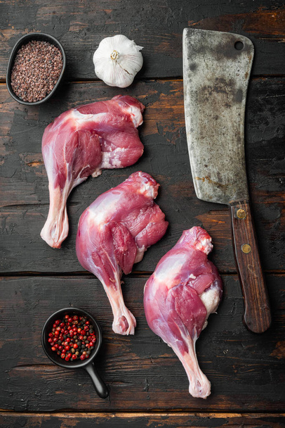 Raw duck thighs set  with old butcher cleaver knife, on old dark  wooden table background, top view flat lay - Photo, Image