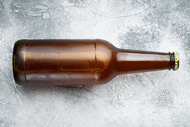 グラスボトル入りのフレッシュビール、灰色の石の背景、トップビューフラットレイ - 写真・画像