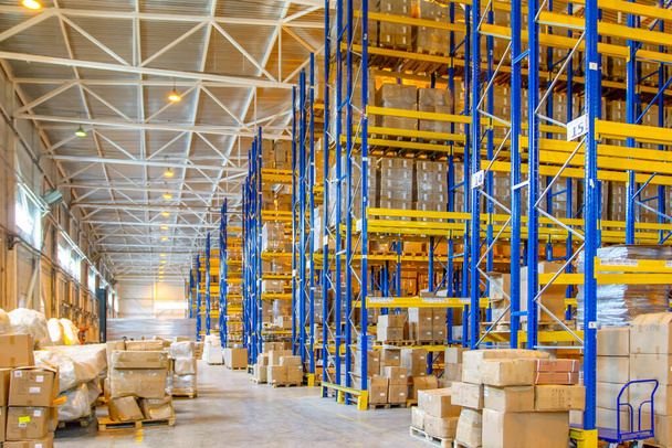 Interior of a modern warehouse storage with rows and goods boxes on high shelves - Foto, Imagen