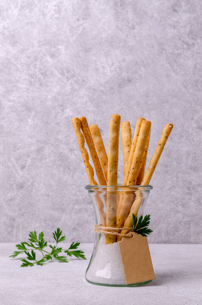 Традиционные хлебные палочки с солью и петрушкой. Селективный фокус. - Фото, изображение