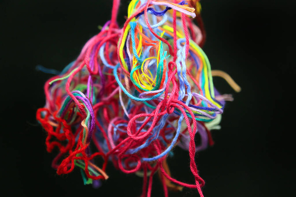 Hilos e hilos de algodón enredados multicolores para el primer plano de la costura sobre fondo negro - Foto, imagen