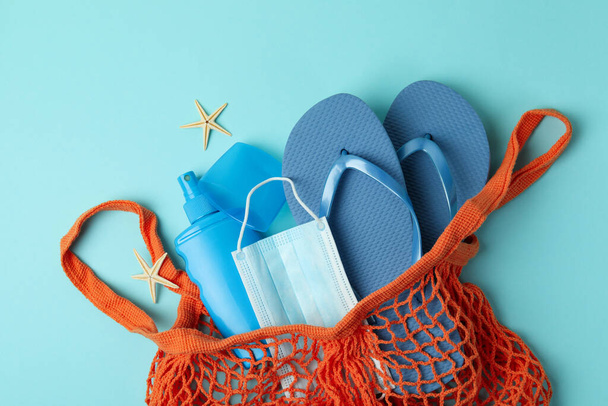 Tasche mit Meerzubehör, Sonnencreme und Maske auf blauem Hintergrund - Foto, Bild