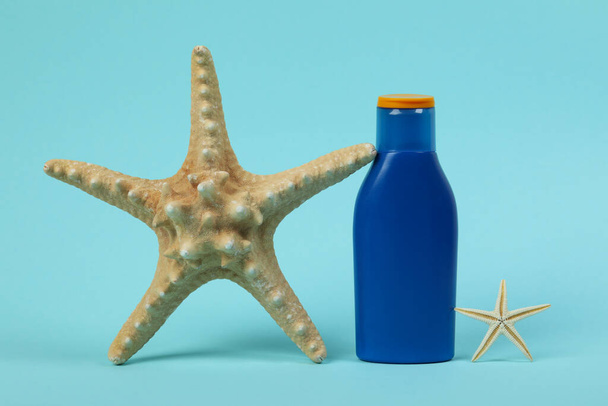 Синя пляшка сонцезахисного крему і зірок на синьому фоні
 - Фото, зображення