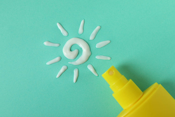 Sunscreen and sun made of cream on mint background - Photo, Image