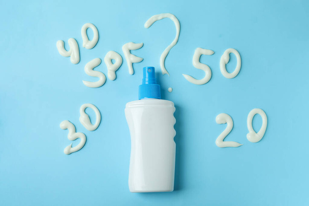 Text SPF? and sunscreen on blue background - Фото, зображення