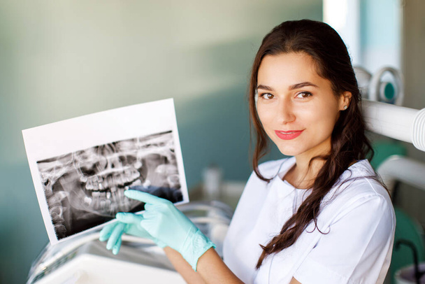 Κοντινό πλάνο γυναίκα οδοντίατρος κρατώντας το στόμα του ασθενούς ψηφιακή μεμβράνη.Γυναίκα γιατρός δείχνει ασθενή από του στόματος σάρωση - Φωτογραφία, εικόνα