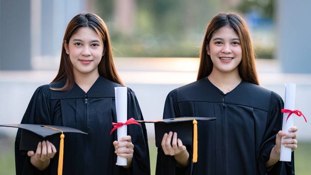Fiatal boldog ázsiai nő egyetemi diplomások ballagási köntös és habarcs van diploma tanúsítvány ünneplik az oktatás teljesítményét az egyetemi campus. Oktatási állomány fényképe - Fotó, kép