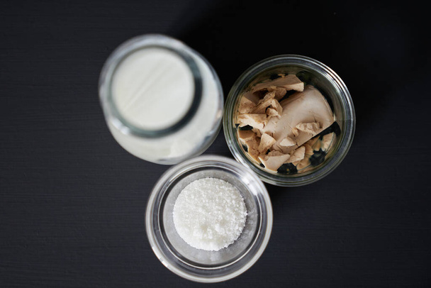 Vista superior de los ingredientes de la masa: azúcar, leche y levadura - Foto, Imagen