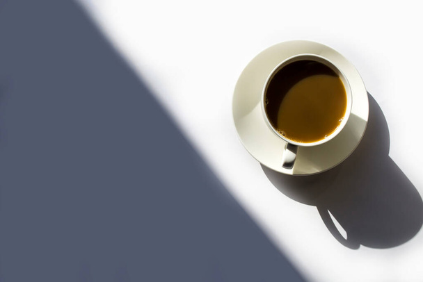 Café de la mañana en una taza blanca en un platillo blanco. - Foto, imagen