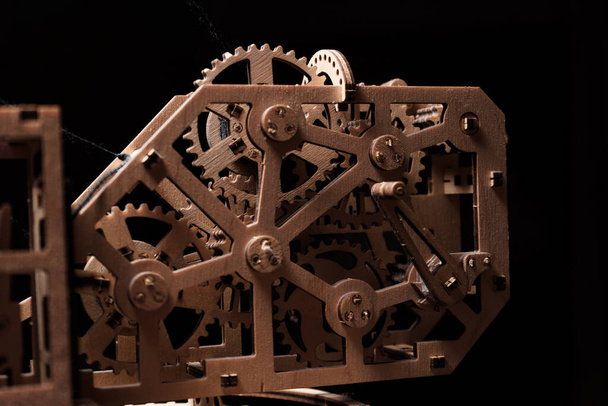 Wooden gears of the mechanism close-up on a black background - Fotó, kép