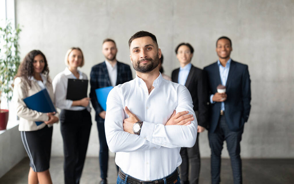 Confident Arabic Businessman Standing In Front Of Employees In Office - Foto, imagen