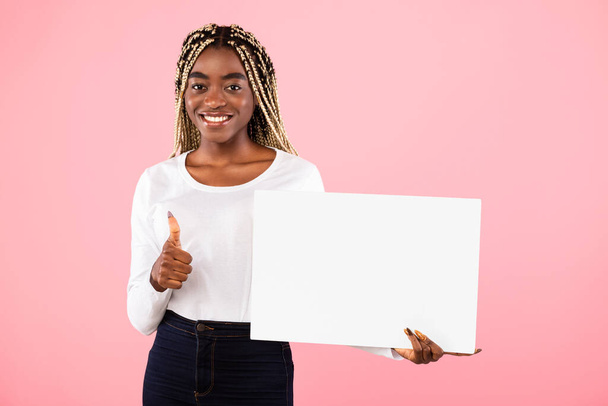 Mujer negra sosteniendo cartelera de publicidad blanca en blanco mostrando pulgares hacia arriba - Foto, imagen