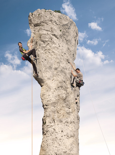 Bergsteiger im Einsatz, junge Frau und Mann erklimmen schwierigen Felsen. - Foto, Bild