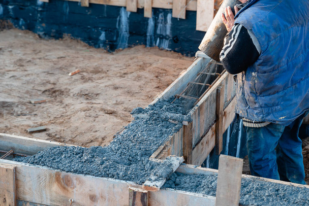 wylewanie betonu z betoniarki na budowie domu jednorodzinnego - Zdjęcie, obraz