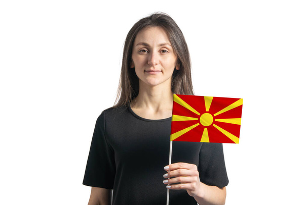 Onnellinen nuori valkoinen tyttö tilalla Pohjois-Makedonian lippu eristetty valkoisella taustalla. - Valokuva, kuva