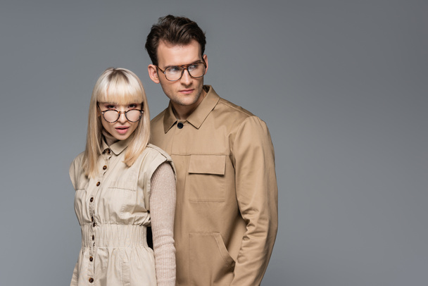 stylish young models in glasses posing isolated on grey - Zdjęcie, obraz