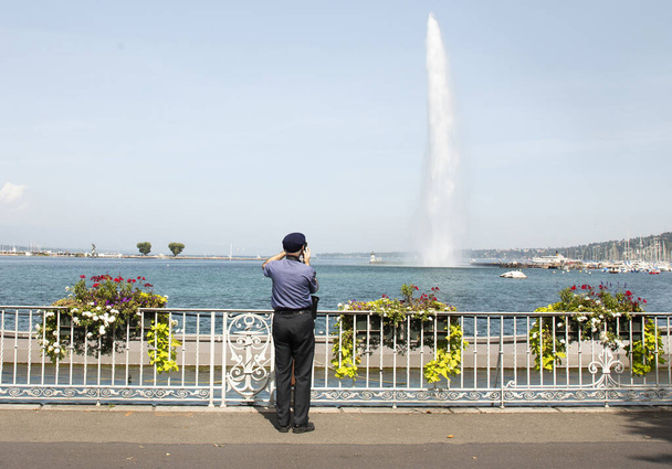 Rear view of man photographing fountain, Geneva, Switzerland - Photo, Image
