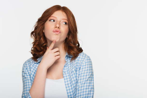 pensive young redhead woman in blue plaid shirt looking away isolated on white - Fotó, kép
