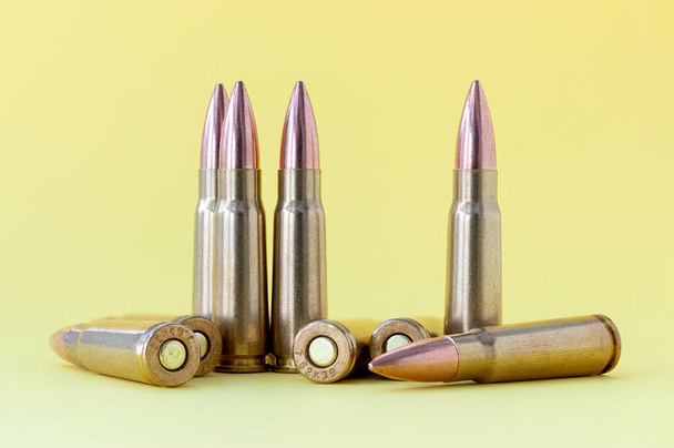 Balas no fundo amarelo. Cartuchos calibre 7.62 para Kalashnikov assalto rifle closeup - Foto, Imagem