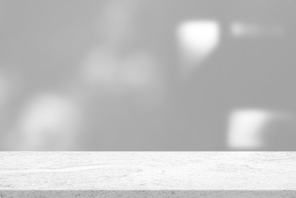 Marmeren tafel met witte betonnen wandtextuur achtergrond met lichtbundel en schaduw, geschikt voor productpresentatie achtergrond, display en Mock up. - Foto, afbeelding