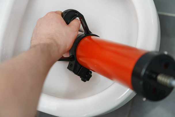 Plumber unclogging toilet with professional force pump cleaner. - Photo, Image