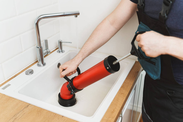 Installateur unclogging Küche Spüle mit professionellen Kraft Pumpe Reiniger. - Foto, Bild