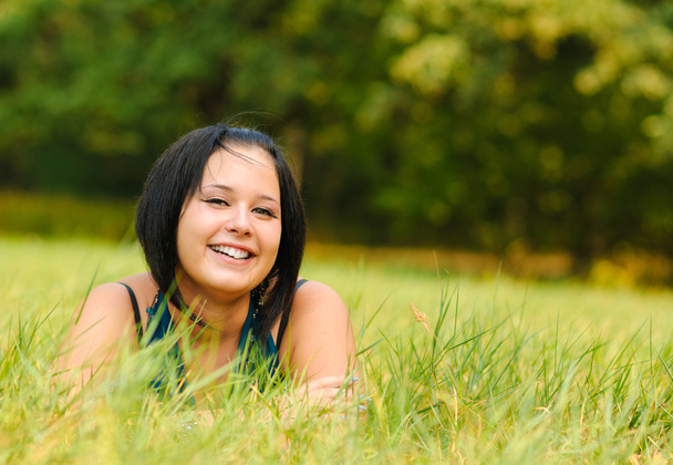 Pretty girl relaxing outdoor on green grass - Photo, Image