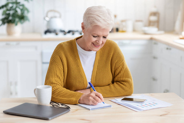 Pozitív idős hölgy szabadúszó otthon dolgozik vagy tanul - Fotó, kép