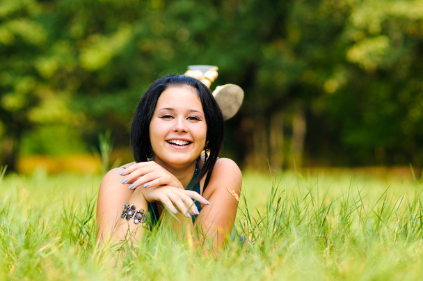 Pretty girl relaxing outdoor on green grass - Fotó, kép