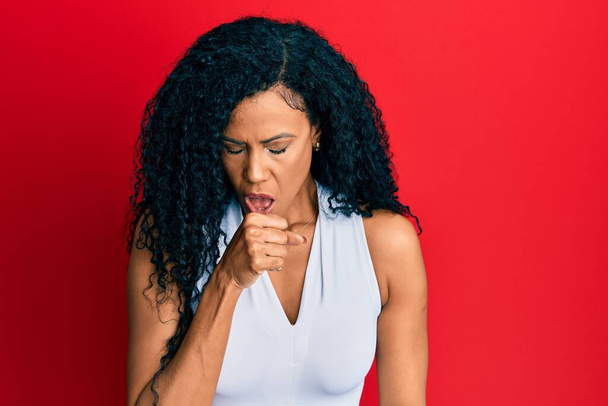 Middle age african american woman wearing casual white t shirt feeling unwell and coughing as symptom for cold or bronchitis. health care concept.  - Photo, Image