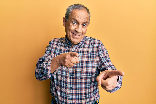 Handsome senior man with grey hair wearing casual shirt pointing fingers to camera with happy and funny face. good energy and vibes.  - Photo, Image