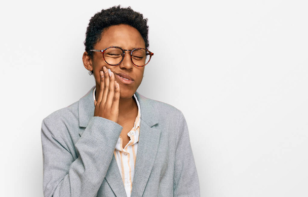 Genç Afro-Amerikan kadın iş elbiseleri giyip diş ağrısı ya da diş hastalığından dolayı ağızlarına acı dolu bir ifadeyle dokunuyor. dişçi  - Fotoğraf, Görsel