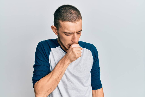Іспанський молодий чоловік, який носить повсякденний одяг, почувається погано і кашляє, як симптом до холоду або бронхіту. концепція охорони здоров'я.  - Фото, зображення