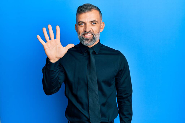 Homem bonito de meia idade vestindo camisa de negócios e gravata mostrando e apontando para cima com os dedos número cinco, sorrindo confiante e feliz.  - Foto, Imagem
