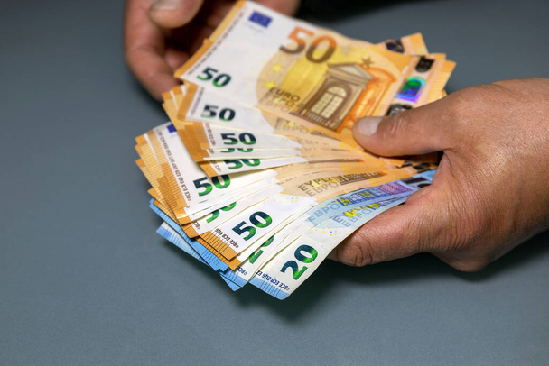 Manual counting of euro banknotes. Cash, 50 euro bills and 20 euro bills. - Foto, afbeelding