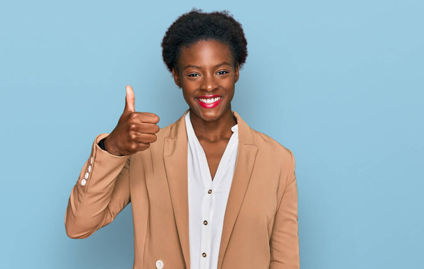 Young african american girl wearing business clothes smiling happy and positive, thumb up doing excellent and approval sign  - Foto, afbeelding