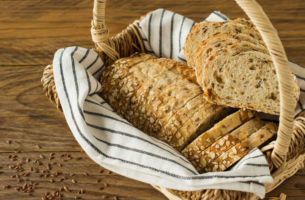 Gluten-free vegan bread with no animal products. Vegetarian bread with oatmeal, banana flavor in a basket on a wooden rustic table, sliced and ready to serve - Foto, Bild