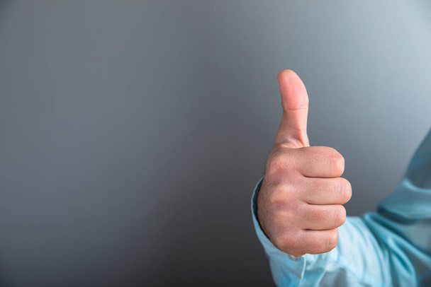 man showing thumb up on gray background - Foto, imagen