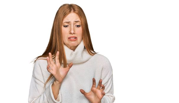 カジュアルな冬のセーターを着て若いアイルランドの女性は、嫌悪反応のために嫌悪感の表情、不満と恐ろしいやって嫌悪感の顔をうんざり.  - 写真・画像