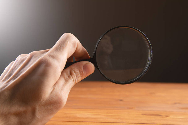 man holding a magnifying glass search for information - Foto, Bild