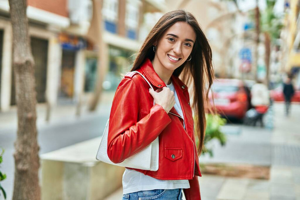 Jeune femme hispanique souriant heureux debout à la ville. - Photo, image